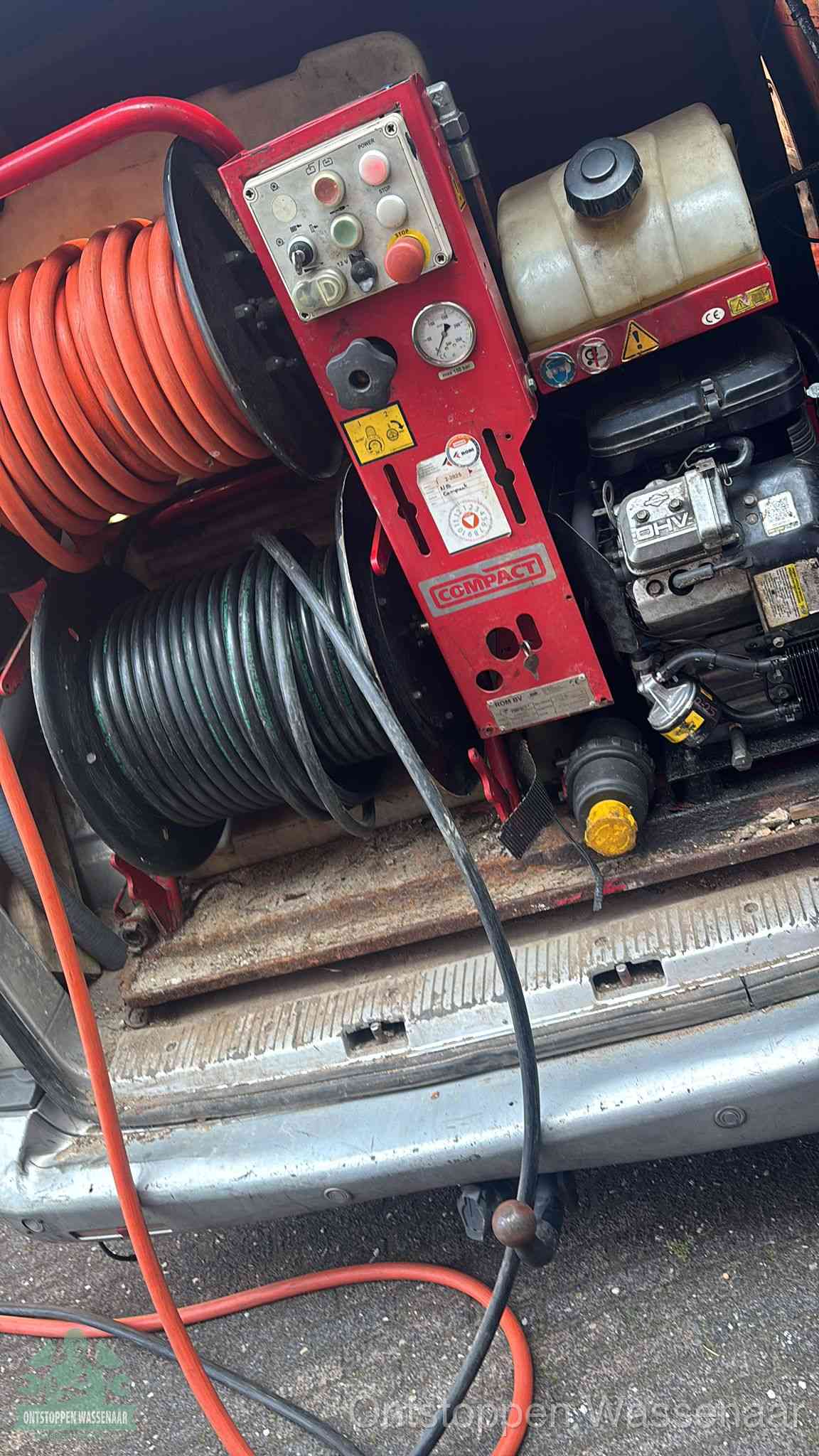 Een rood hogedruk-rioolreinigingstoestel in de laadbak van de bedrijfsbus, apparatuur voor een hardnekkige afvoerverstopping in Wassenaar
