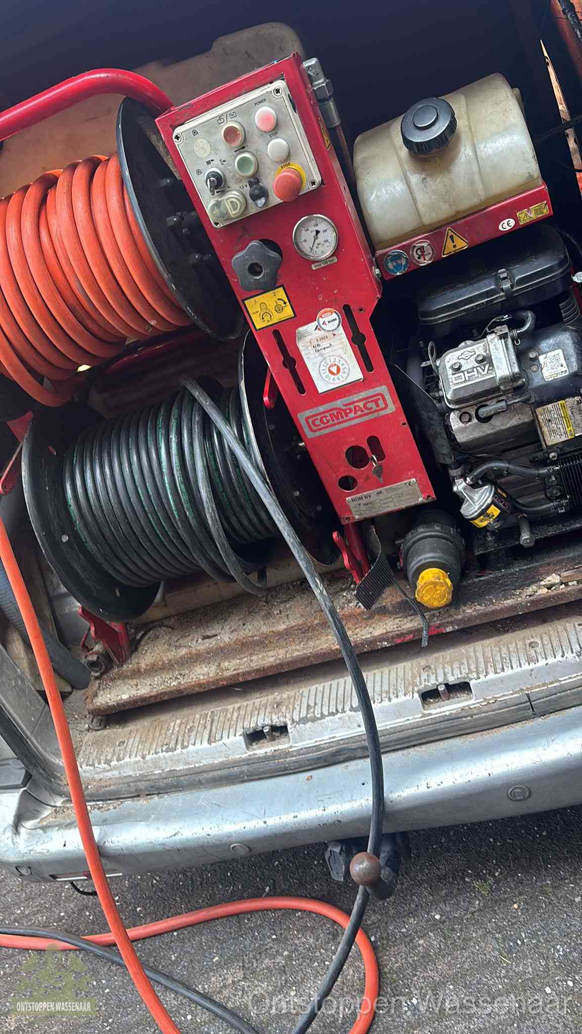Een rood hogedruk-rioolreinigingstoestel met slangen in de laadbak van de bedrijfsbus, apparatuur voor een hardnekkige wc-verstopping in Wassenaar
