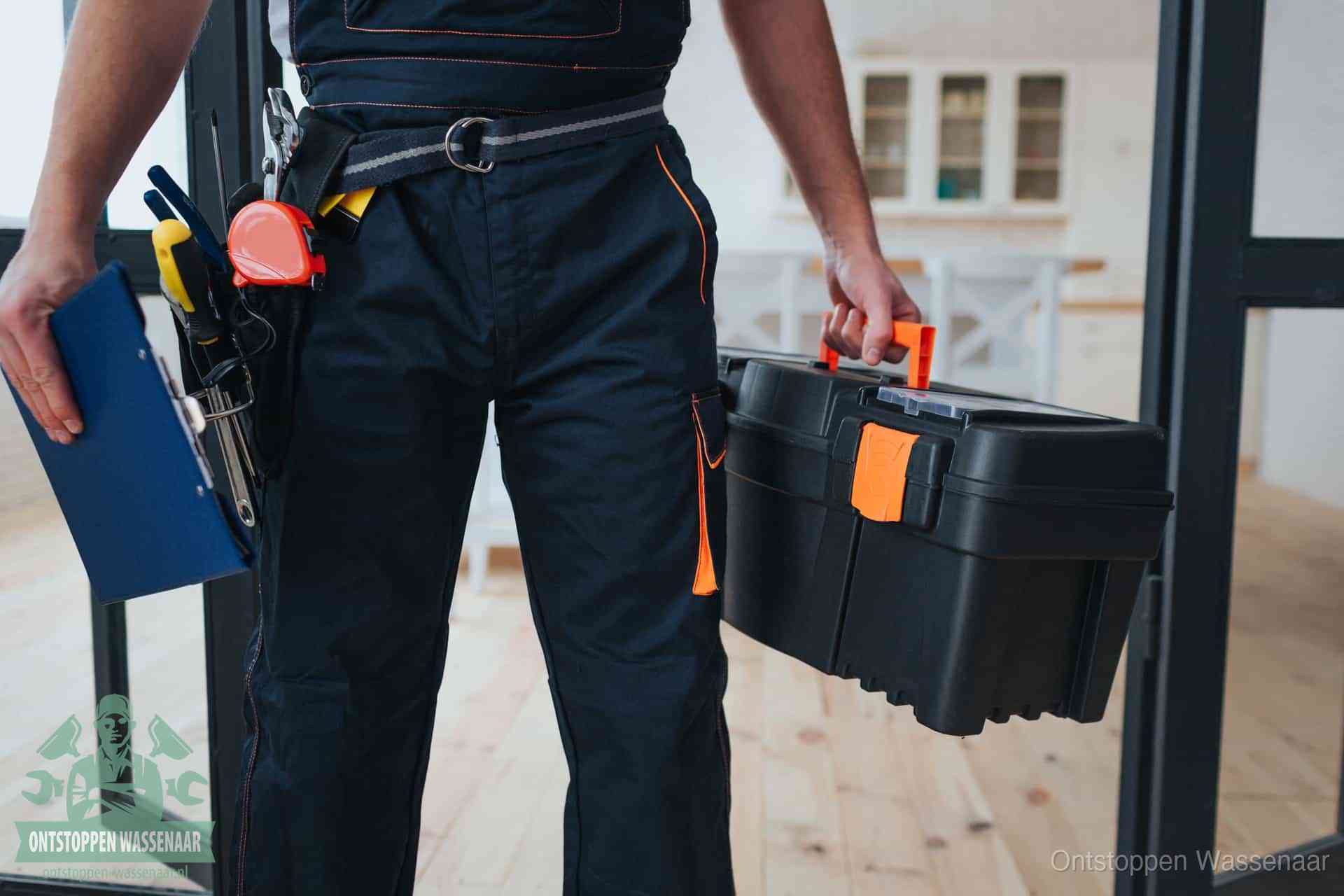 Een monteur met gereedschapsriem en klembord, klaar om een transparante prijs voor het afvoer ontstoppen in Wassenaar te geven
