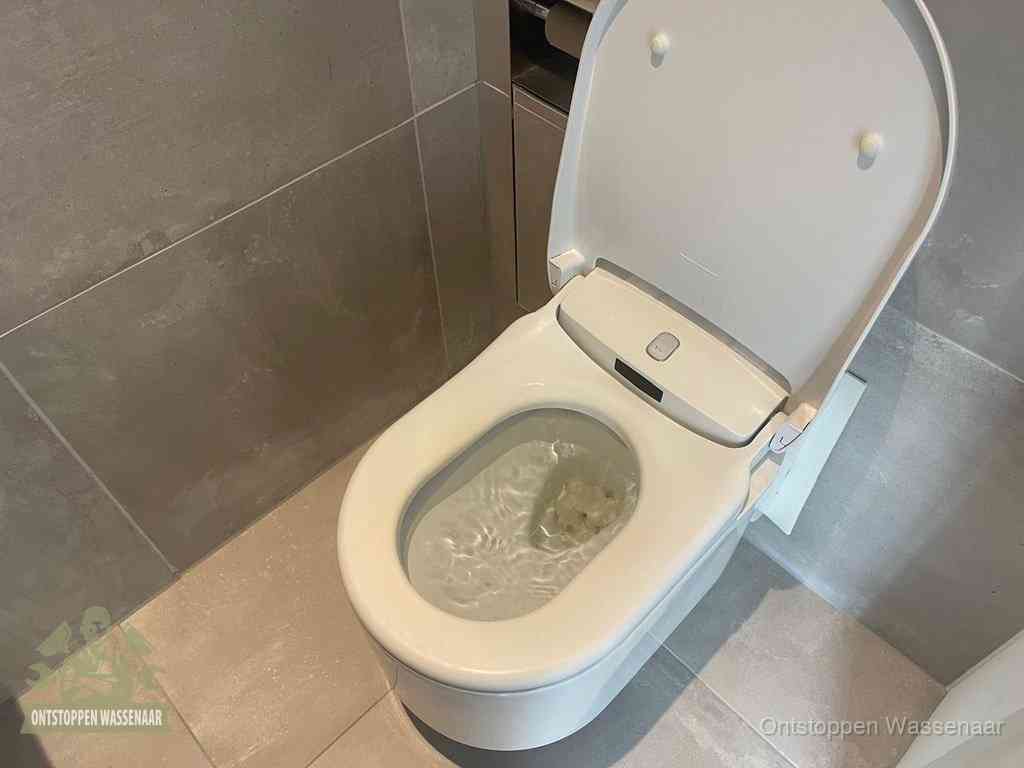 Een toiletpot vol troebel water met drijvend papier en restanten, de meest voorkomende oorzaak van een verstopte wc in Wassenaar