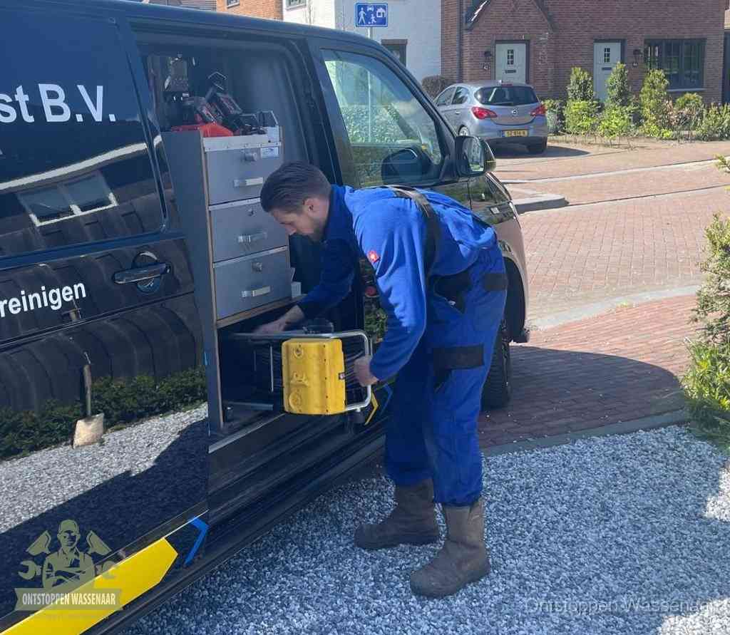 Een monteur pakt apparatuur uit de bedrijfsbus voor service aan huis, het moment om een professional in te schakelen in Wassenaar