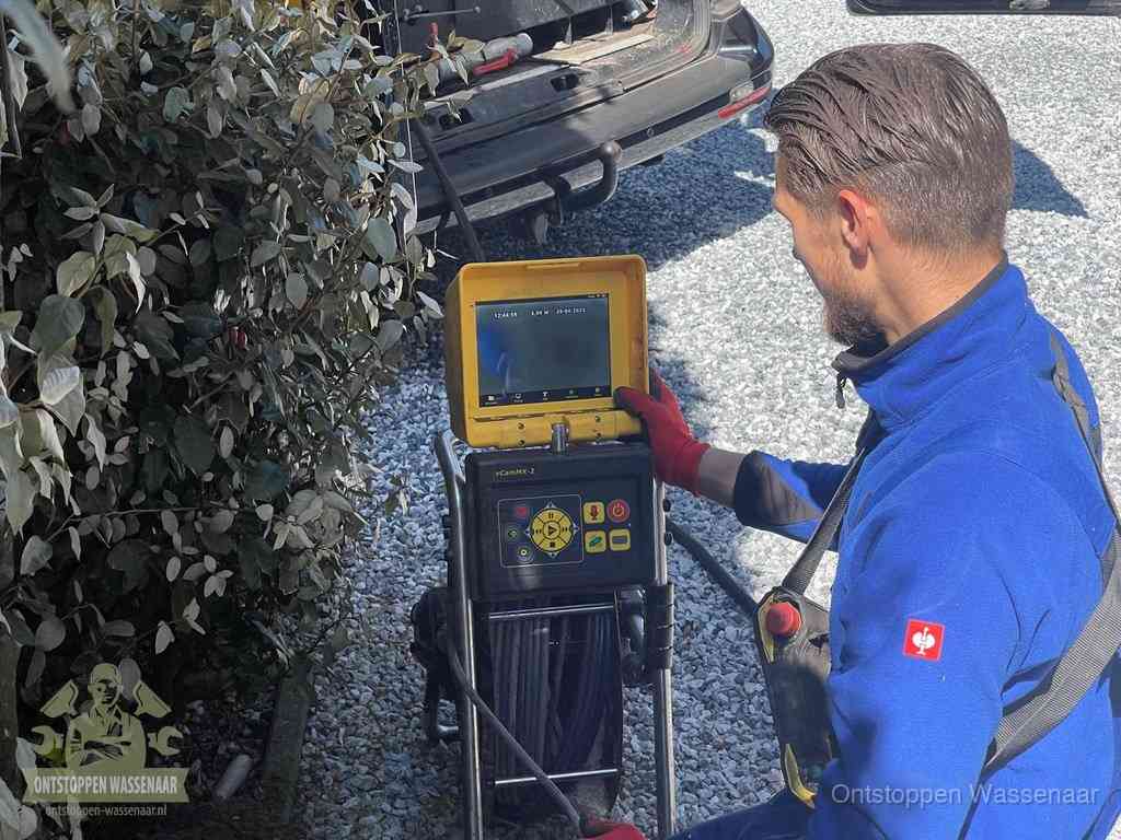 Monteur bedient een rioolinspectiecamera met monitor voor rioolinspectie in Wassenaar