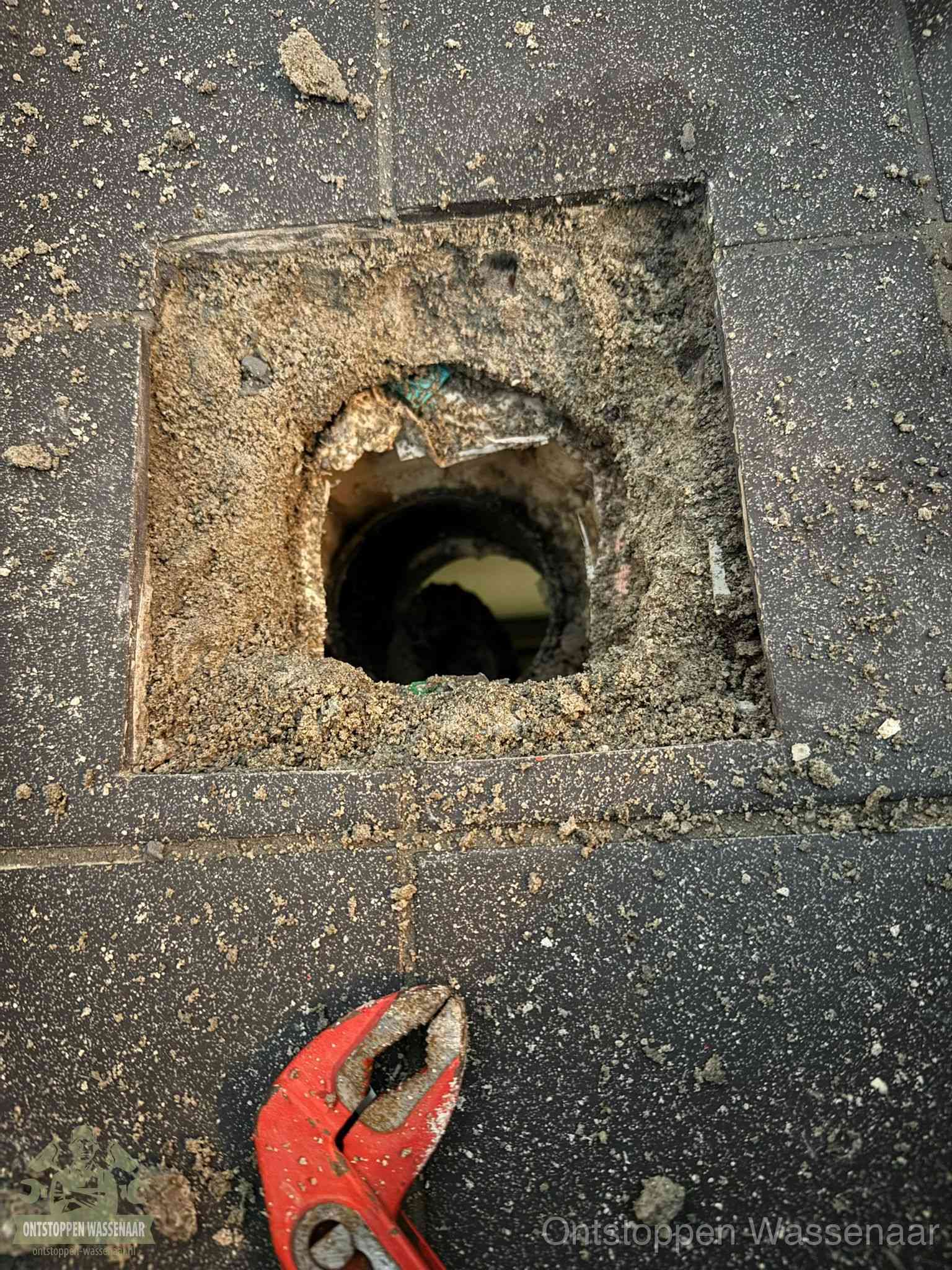 Geopend rioolputje op de erfgrens dat laat zien wie eigenaar is van de riolering in Wassenaar