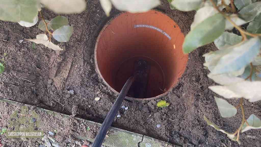 Open inspectieput in de tuin waar een veer rioolvliegjes en stankoverlast aanpakt in Wassenaar