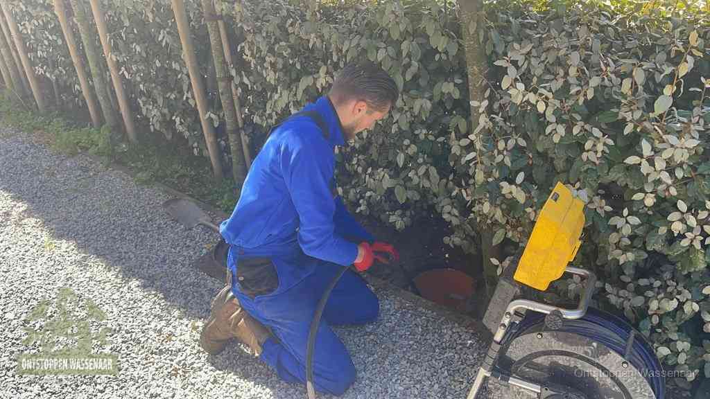 Monteur aan het werk bij een rioolput, de werkwijze voor riool ontstoppen in Wassenaar