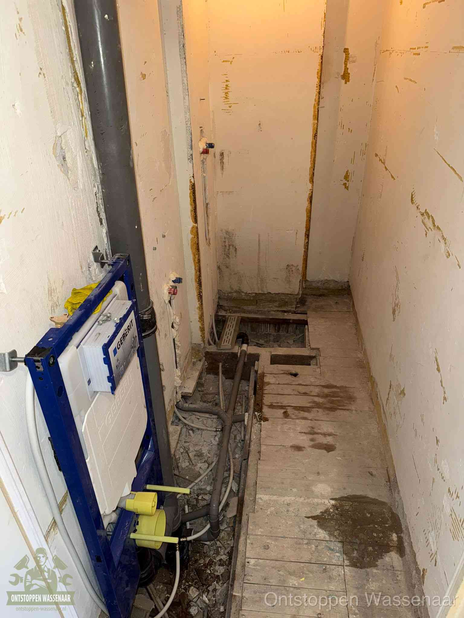 Een opgebroken toiletruimte tijdens renovatie met een Geberit inbouwreservoir en blootliggende oude afvoerleidingen, typisch voor oudere woningen in Wassenaar